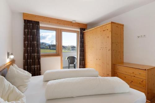 a hotel room with two beds and a window at Stiflerhof Apt Enzian in Falzes