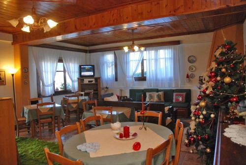 a living room with a christmas tree and a room with a living room at 2 Alonia in Anatolikí Frangísta