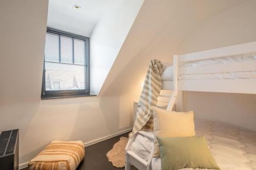 Habitación blanca con litera y ventana en BEACH 52 duplex appartement met terras, en Knokke-Heist
