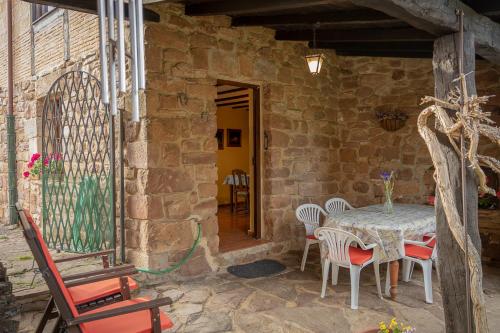 a stone house with a table and chairs on a patio at La Casa de Salinas in Salinas de Pisuerga