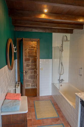a bathroom with a bath tub and a sink at La Casa de Salinas in Salinas de Pisuerga