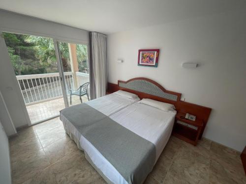 a bedroom with a large bed and a balcony at Apartamentos Sol Radiante in Canyamel
