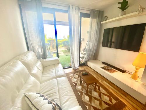 un salon avec un canapé blanc et une grande fenêtre dans l'établissement Le Delacroix 2 By SCLS Locations, à Cannes