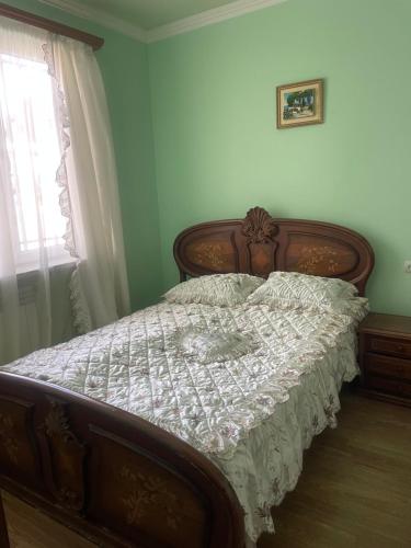 a bedroom with a bed with a white comforter and a window at Nelly's Home in Yerevan