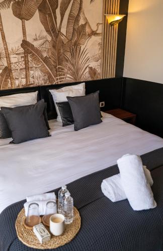 a hotel room with a bed with two towels and two cups at Hôtel Gallia Cannes in Cannes