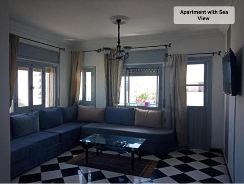 ein Wohnzimmer mit einem blauen Sofa und einem Tisch in der Unterkunft Martil Center Apartments in Martil