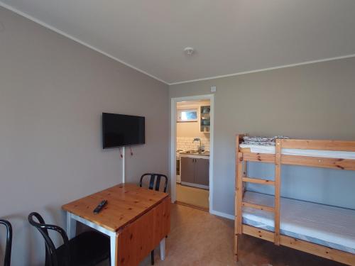 Zimmer mit einem Schreibtisch, einem Etagenbett und einem Tisch in der Unterkunft Vena Värdshus in Vena