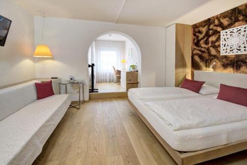 sala de estar con 2 camas y sofá en Hotel Schlair en Kremsmünster