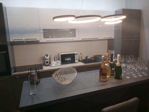 a kitchen with wine bottles and glasses on a counter at Apartman Golden in Senta