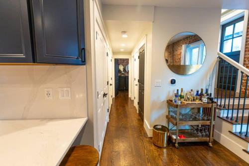 einen Flur eines Hauses mit Holzboden und einem Spiegel in der Unterkunft Historic Modern 6 Full Bath & 6 Bedrooms-near LoHi in Denver