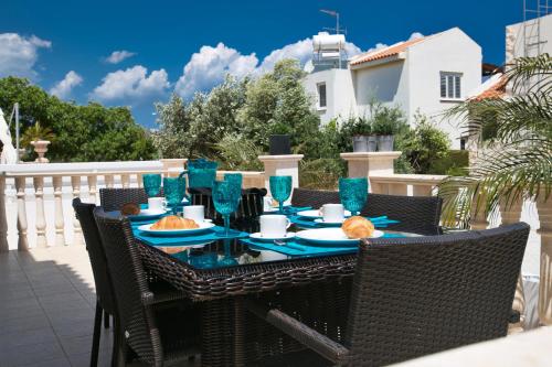 una mesa con gafas azules y comida en el patio en Tonia Seaview Villas, en Protaras