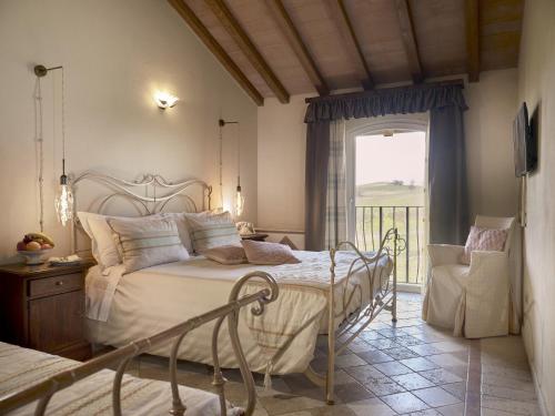 um quarto com uma cama e uma varanda em Tenuta Montemagno Relais & Wines em Montemagno