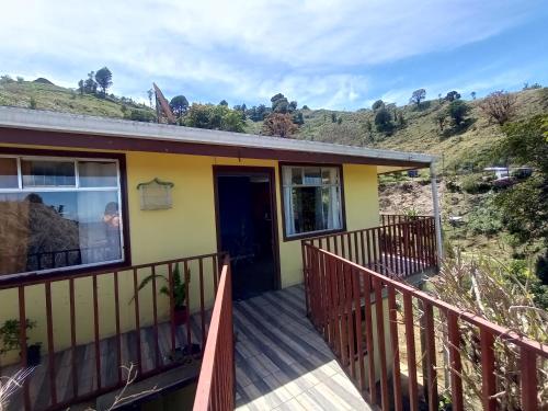 ein Haus mit einer Holzterrasse mit einer Tür in der Unterkunft Finca el Calar El mejor lugar para buscar la paz in Empalme