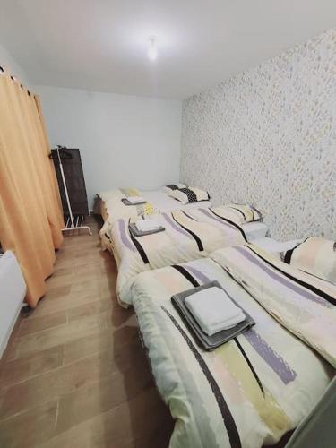 une rangée de 4 lits dans une chambre dans l'établissement Family flat Stade de France airport CDG Le Bourget "Appart'7", à Pierrefitte-sur-Seine