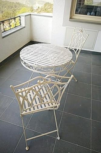 a white table and chair on a balcony at Turisalba in Ishëm