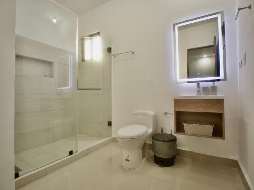 uma casa de banho com um WC e uma cabina de duche em vidro. em Casa Pardo em Monterrey