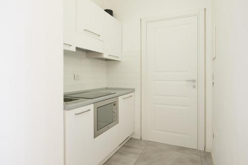 a kitchen with white cabinets and a stove top oven at Relais Vittorio Veneto - Luxotel & Apartotel in Salerno
