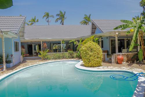 a swimming pool in front of a house at Seven Palms Villa in Runaway Bay