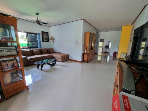 a living room with a couch and a tv at Puree Poolvilla Sattahip in Sattahip