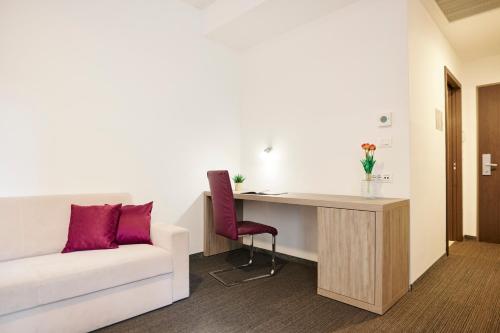 a living room with a couch and a desk at Hotel Meksiko in Ljubljana