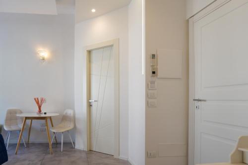 a white room with a table and chairs and a door at Relais Vittorio Veneto - Luxotel & Apartotel in Salerno
