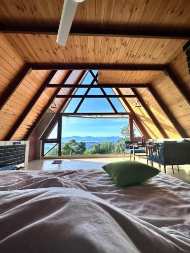 Cama en habitación con ventana grande en The Cloud Resort en Kadugannawa