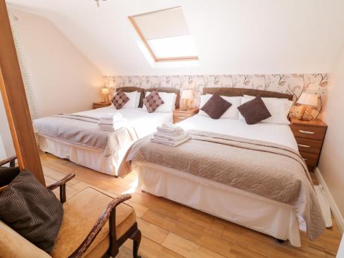 a bedroom with two beds and a skylight at Inverbeg Cottage 2 in Downings
