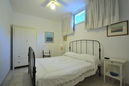 a white bedroom with a bed and a window at CASA NEL VERDE CON GIARDINO E PISCINA PRIVATA in Polignano a Mare