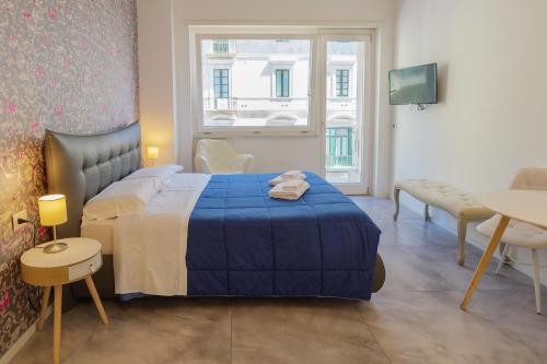 a bedroom with a bed and a table and a window at Relais Vittorio Veneto - Luxotel & Apartotel in Salerno