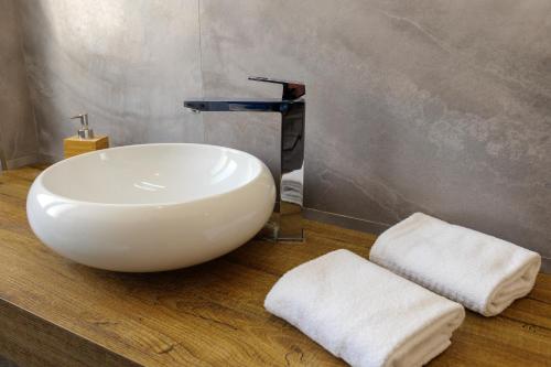 a bathroom with a white sink and two towels at Relais Vittorio Veneto - Luxotel & Apartotel in Salerno