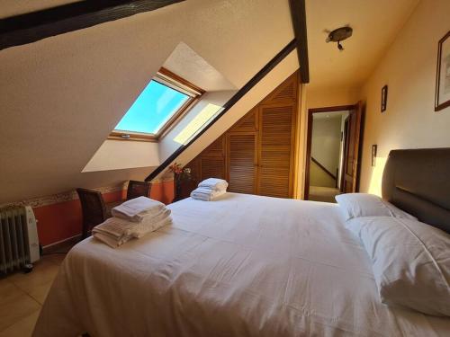 a bedroom with a large white bed with a window at Acogedor dúplex en urbanización con piscina en Ajo in Ajo