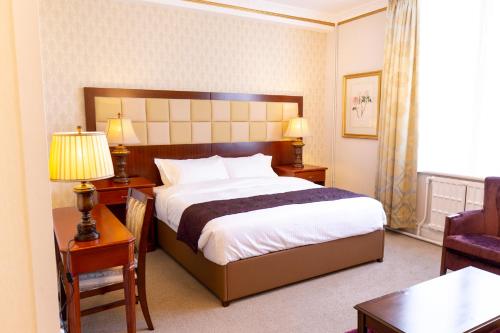 a hotel room with a large bed and a chair at Botleigh Grange Hotel & Spa in Southampton