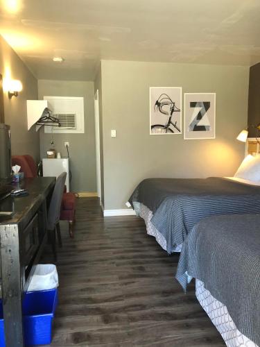 a hotel room with two beds and a desk at Greenside Motel in Saint Andrews