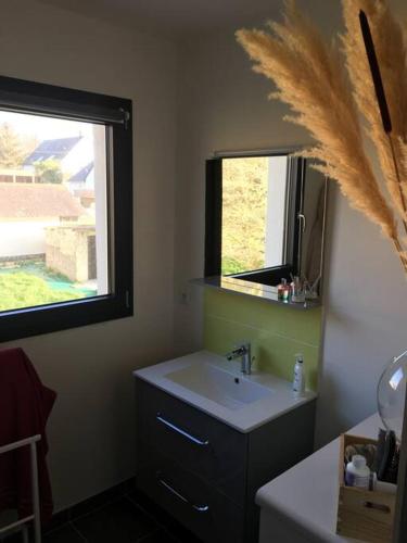 une salle de bain avec un lavabo et une fenêtre dans l'établissement Charmante maison neuve à 2 pas de la mer !!, à Sarzeau