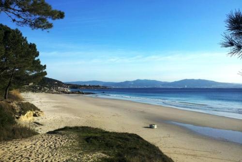 una spiaggia con una ciotola sulla sabbia e sull'oceano di La casita de Meiro a Bueu