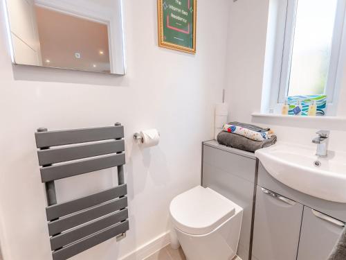 a bathroom with a toilet and a sink and a mirror at Vitamin Sea Residency in Herne Bay