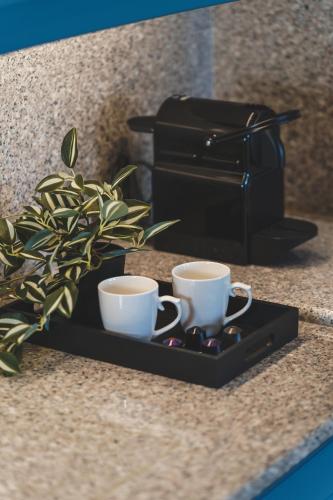 two coffee cups on a tray next to a toaster at Zeus Village Resort - Adults Only in Kato Daratso