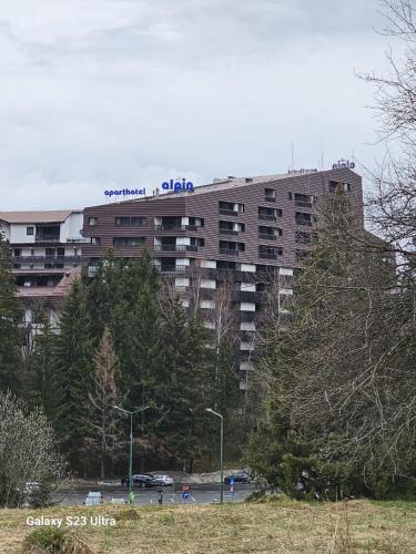a tall building with a sign on top of it at Alpin Aparthotel Ap 508 Poiana Brasov- acces la piscină gratuit in Poiana Brasov