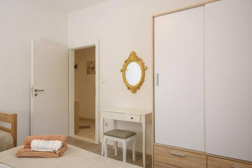 sypialnia z lustrem i biurkiem z krzesłem w obiekcie New apartment with pool and jacuzzi only for you w mieście Kaštela