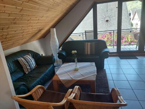 a living room with a couch and a table at Ferienwohnung Gästehaus Schmiedel in Bruttig-Fankel