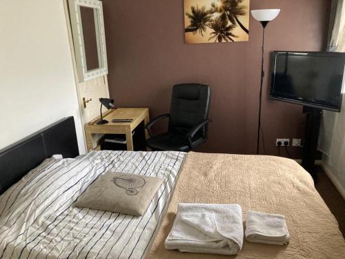 1 dormitorio con 1 cama, 1 silla y TV en LIMEHOUSE upon THAMES ROOM IN Great location en Londres