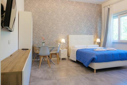 a bedroom with a bed and a table and a chair at Relais Vittorio Veneto - Luxotel & Apartotel in Salerno