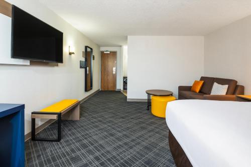 a hotel room with a bed and a couch and a tv at Comfort Inn & Suites in Barrie
