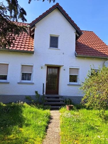 une maison blanche avec un toit rouge dans l'établissement Gästehaus Six Inn mit Gemeinschaftsküche bis 6 Personen, à Uttenweiler