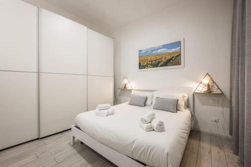 a white bedroom with a large white bed in it at [Old Town] Via Marsala Apartment in Bologna