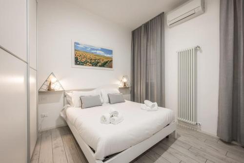 um quarto branco com uma grande cama branca em [Old Town] Via Marsala Apartment em Bolonha