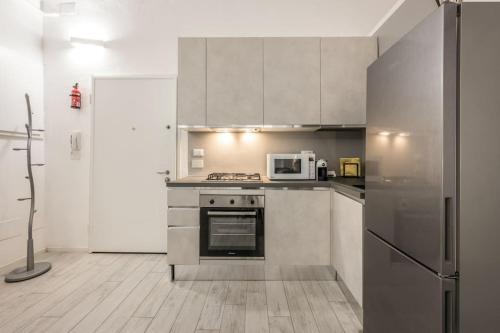 a kitchen with stainless steel appliances and a refrigerator at [Old Town] Via Marsala Apartment in Bologna