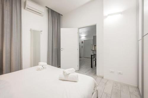 a white bedroom with a bed and a mirror at [Old Town] Via Marsala Apartment in Bologna