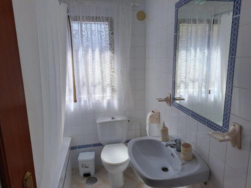 a white bathroom with a toilet and a sink at CASA ORIOL in Ayamonte