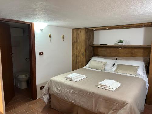 sypialnia z łóżkiem z ręcznikami w obiekcie Appartamento al Centro Storico di Cori Alto w mieście Cori